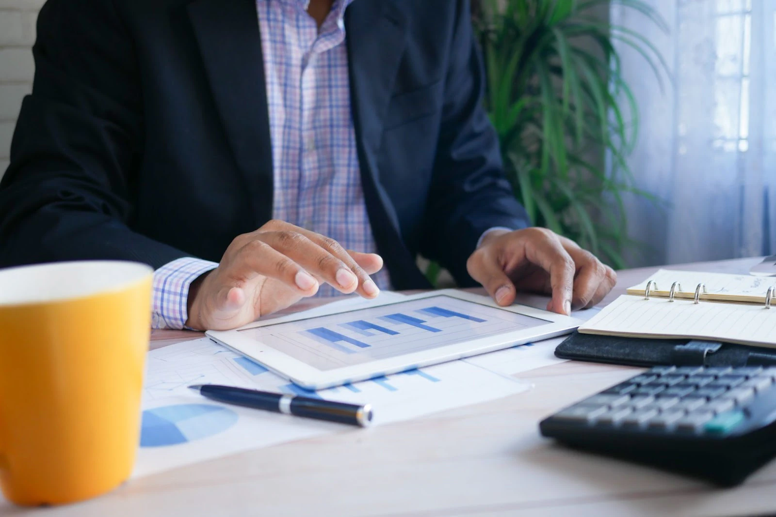 صاحب مشروع يراجع مخططات مالية باستخدام آلة حاسبة