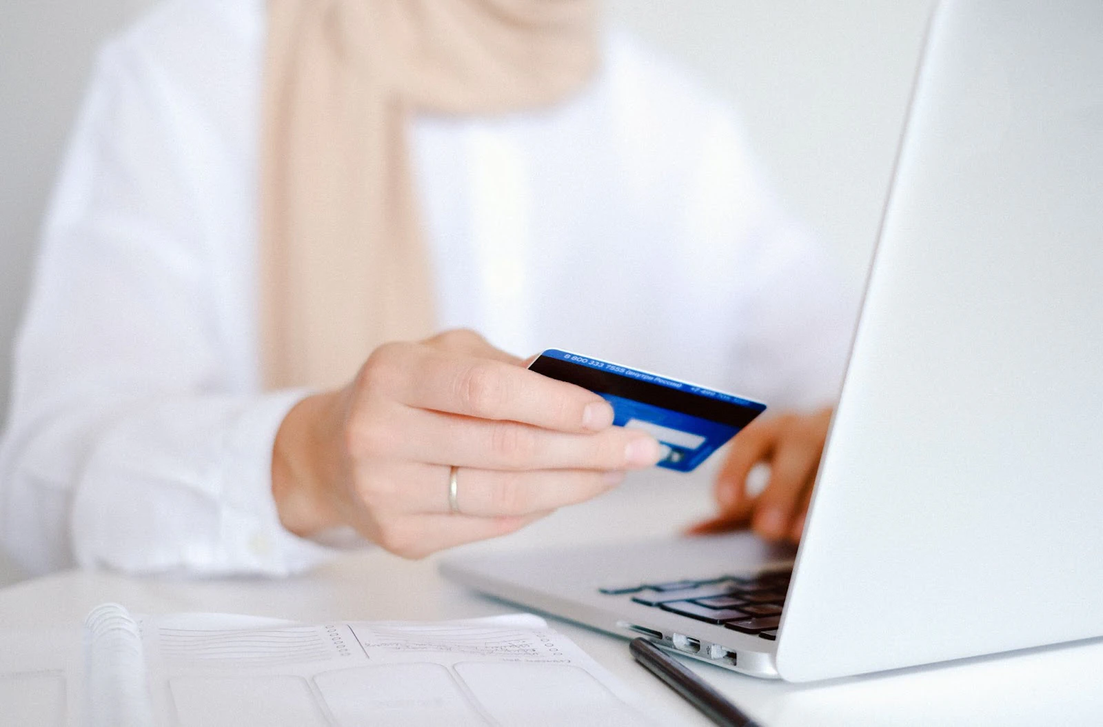 عميل يستخدم بطاقة للدفع عبر حاسوب محمول