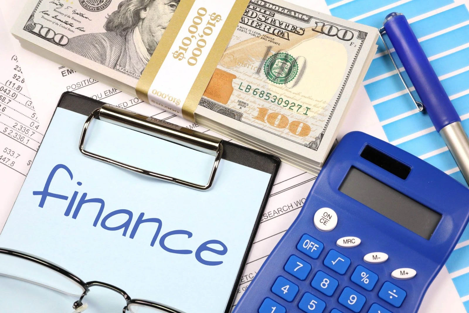 مستندات تمويل وأوراق نقدية وآلة حاسبة لدعم مشروع صغير